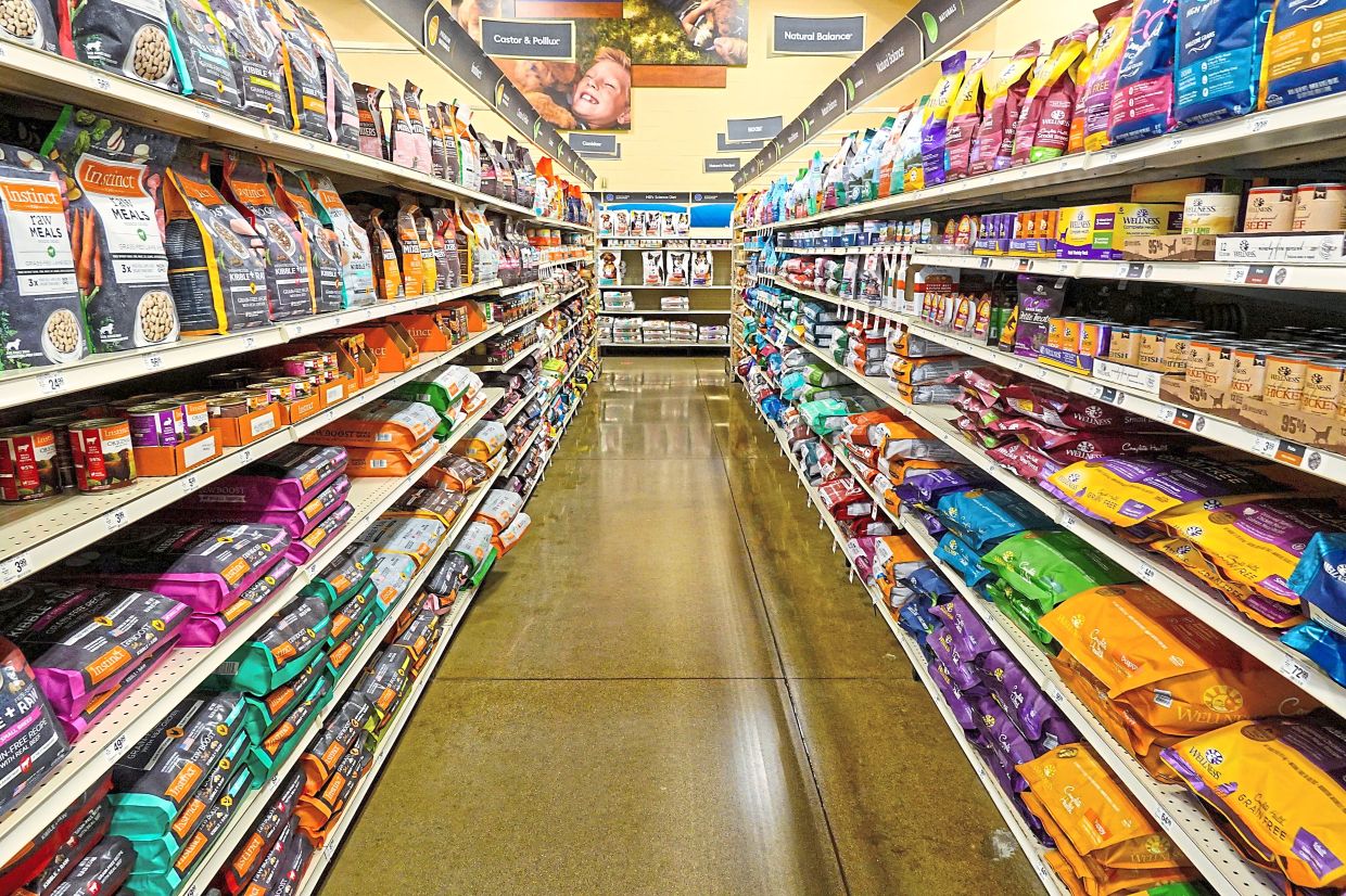 Dog food sits on shelves in a pet store in Westfield, Ind., July 19, 2022. (AP Photo/Michael Conroy, File)