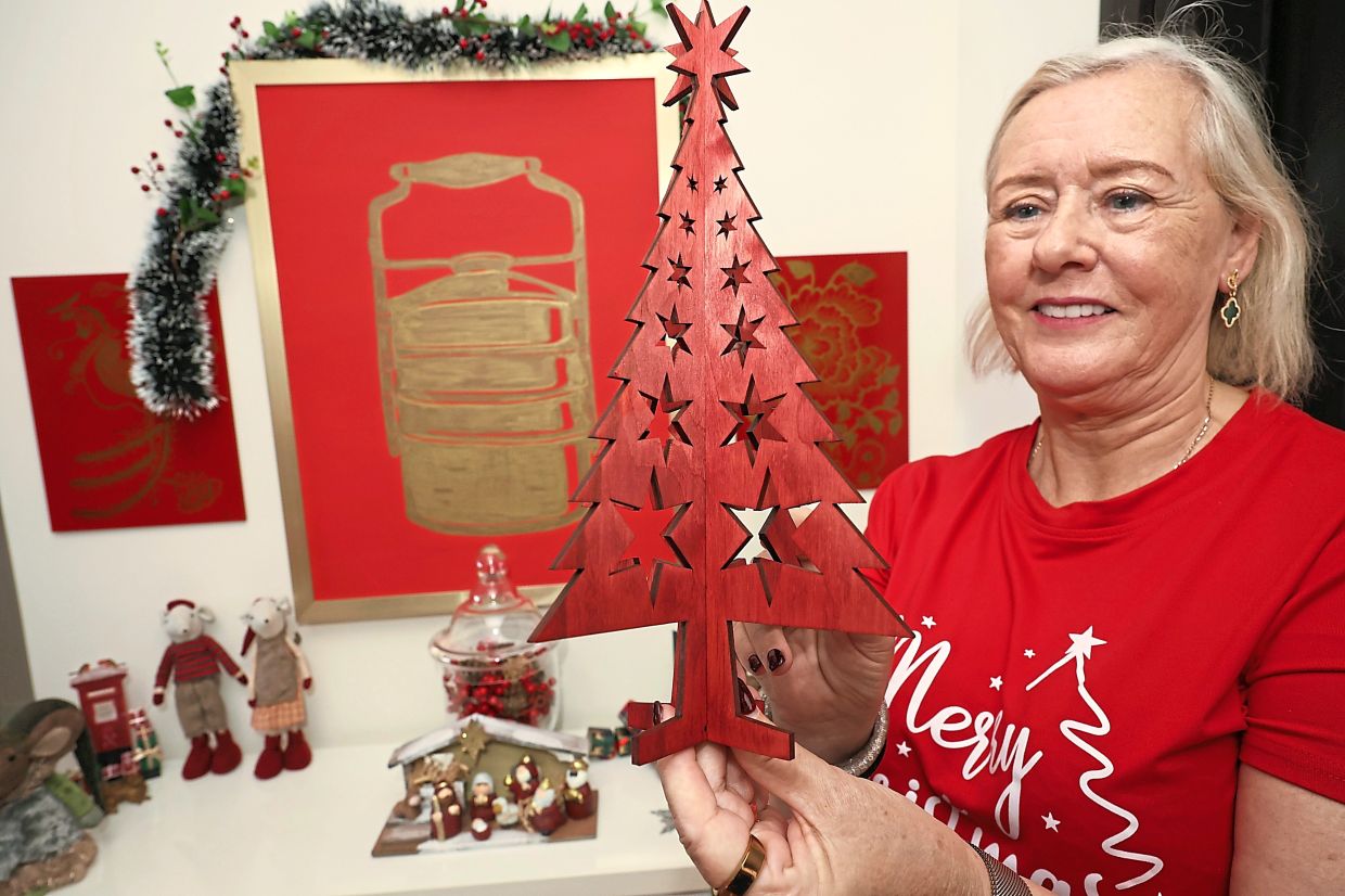 Deborah with her newest addition, a wooden Christmas tree from Iceland.