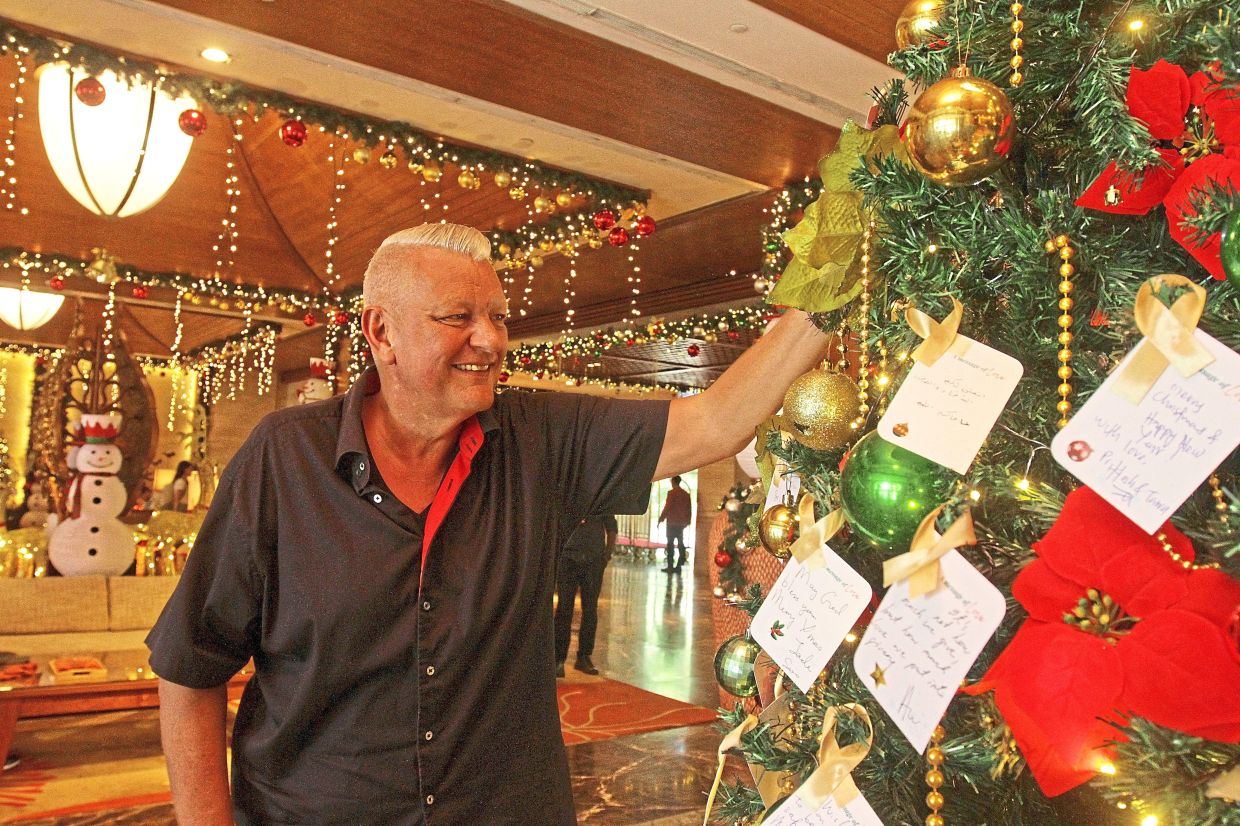 Stalp reading the festive wishes hung on the resort’s Christmas tree. The wishes are submitted by underprivileged children.