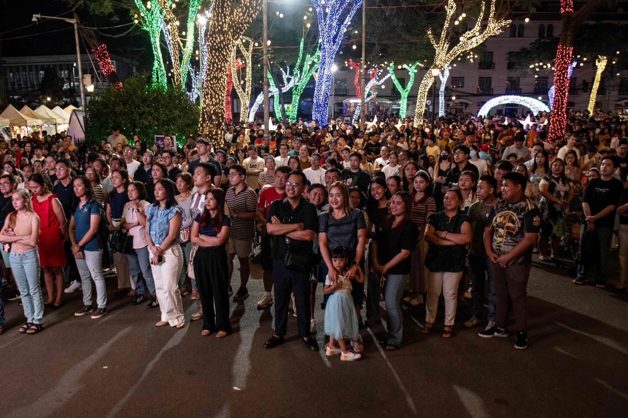 Catholic faithful attend a Christmas Eve mass in front of the Manila Cathedral in Manila on Wednesday, December 24, 2025. -- Photo by Ted ALJIBE / AFP