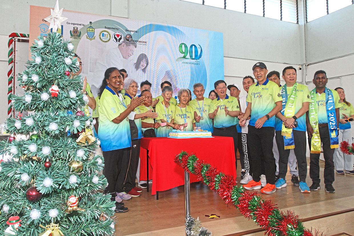 Chow (front row, fourth from right) with organisers and Silver Jubilee Home residents celebrating with an anniversary cake. — Photos: LIM BENG TATT/The Star