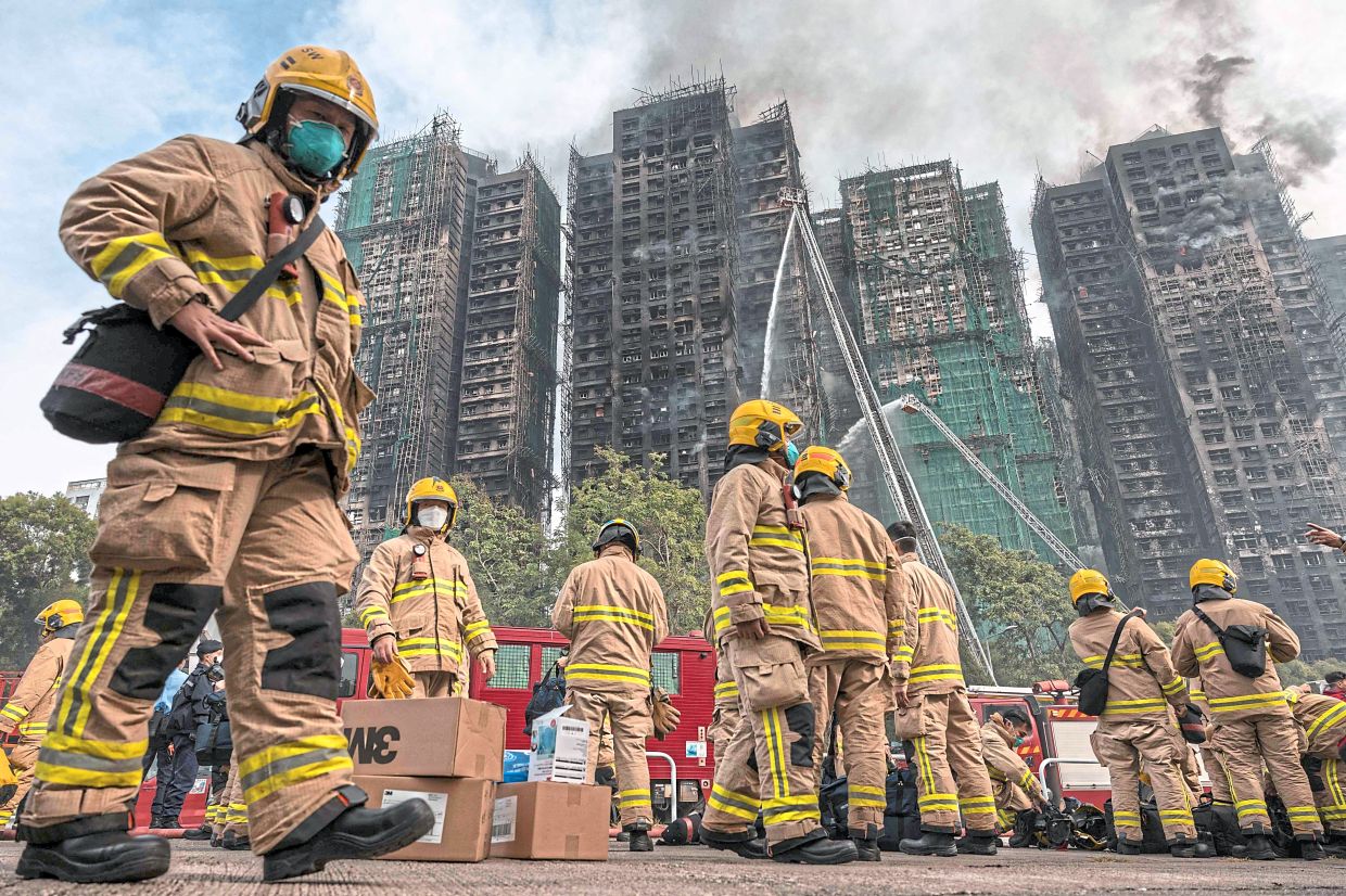File photos show firemen getting ready to enter the Wang Fuk Court residential estate. -AFP
