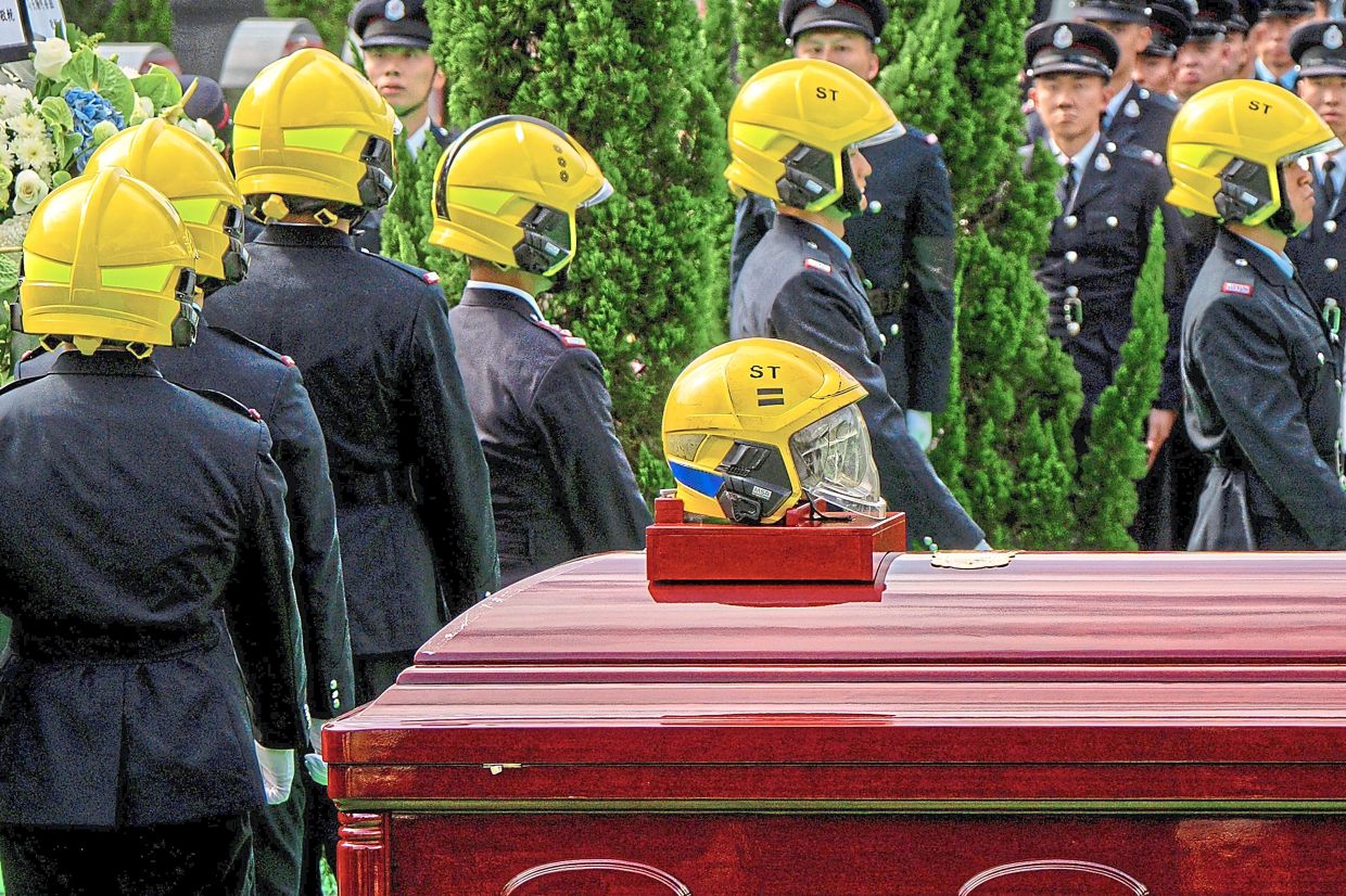 The funeral procession of firefighter Ho Wai-ho, who died in the deadly blaze. — AFP