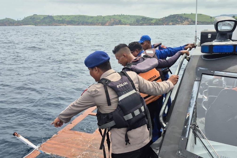In this photo released by the Indonesian National Search and Rescue Agency (BASARNAS) on Saturday, Dec. 27, 2025, rescuers examine debris believed to be from a tour boat that sank near Padar Island within Komodo National Park, Indonesia. -- Photo: BASARNAS via AP
