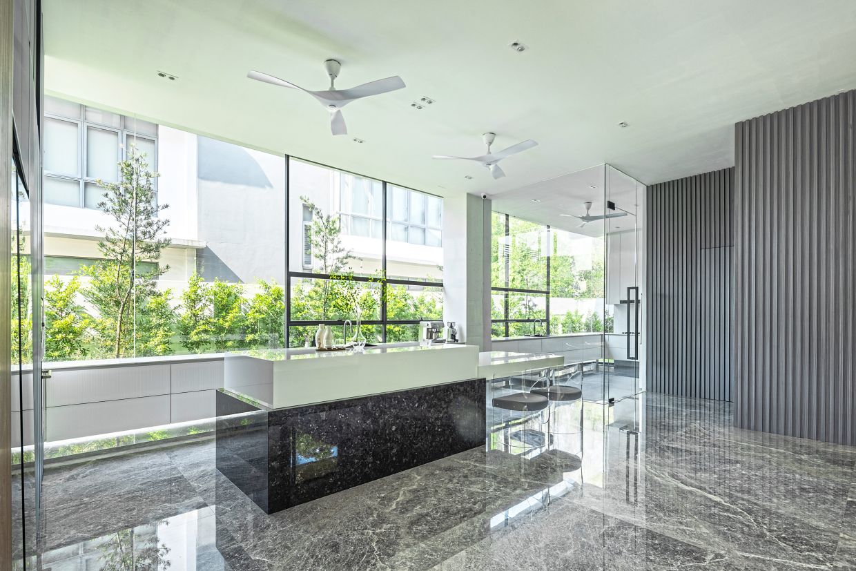 The dry kitchen with an island in the middle, and the ‘floating’ cabinets along the glass wall.