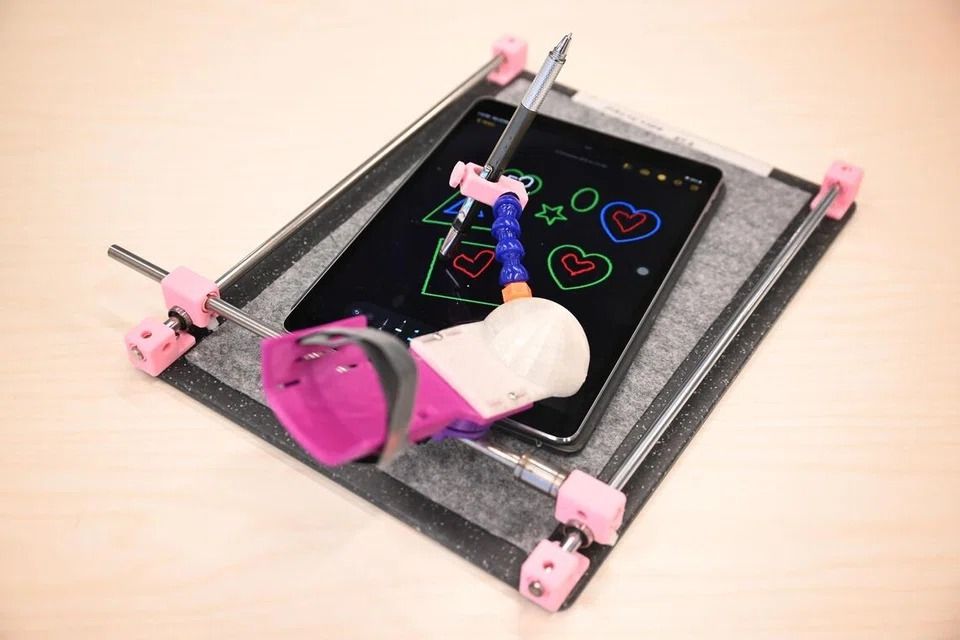 Designed for individuals with grip issues, this 3D-printed pen holder provides stable support for writing and drawing. - ST