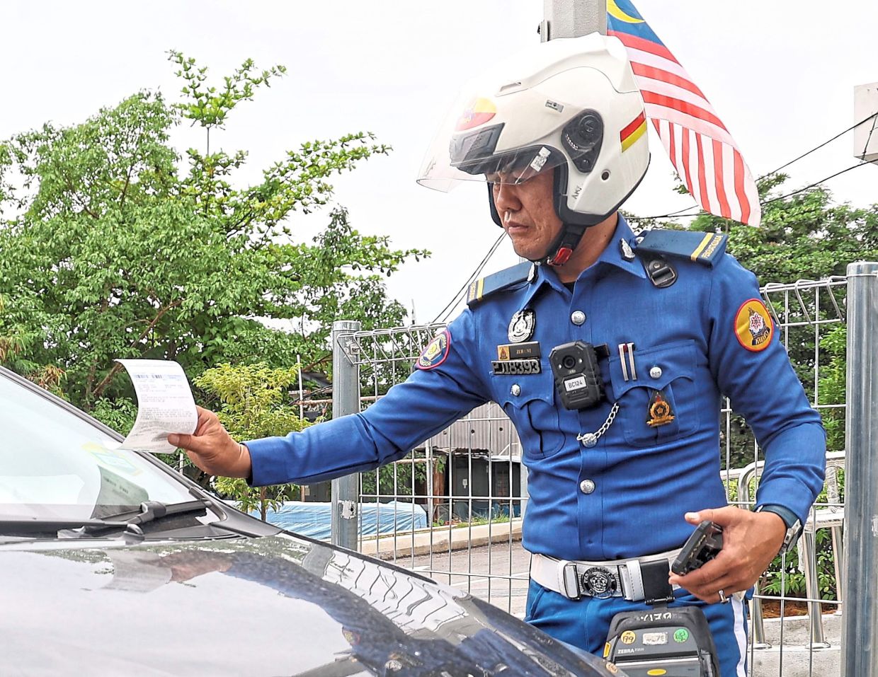 An enforcement officer issuing a summons. MBPJ is one of four local councils identified for implementation of the Selangor Intelligent Parking system.