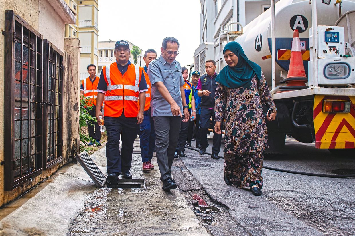 Mohd Sakeri (centre) checking on the cleanliness of a commercial area during a PPj operation. — Bernama