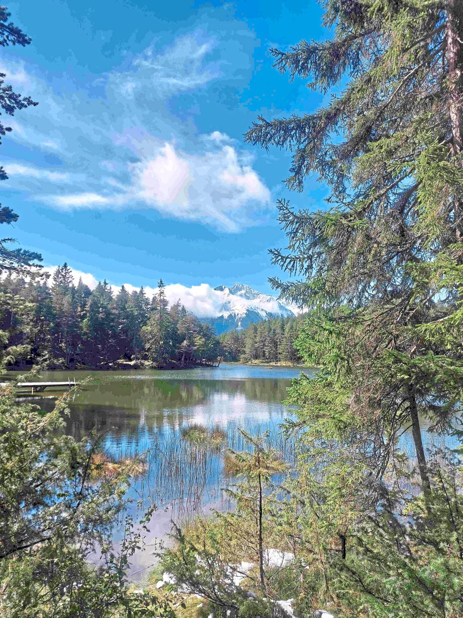 The blue sky and trees reflected on Moserer Lake. 