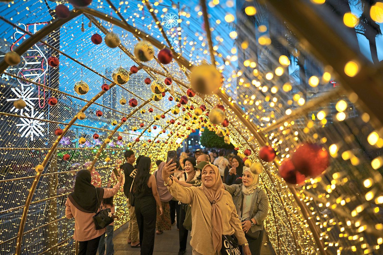 9. People taking selfies under a Christmas light display in Jakarta, Indonesia. — AP