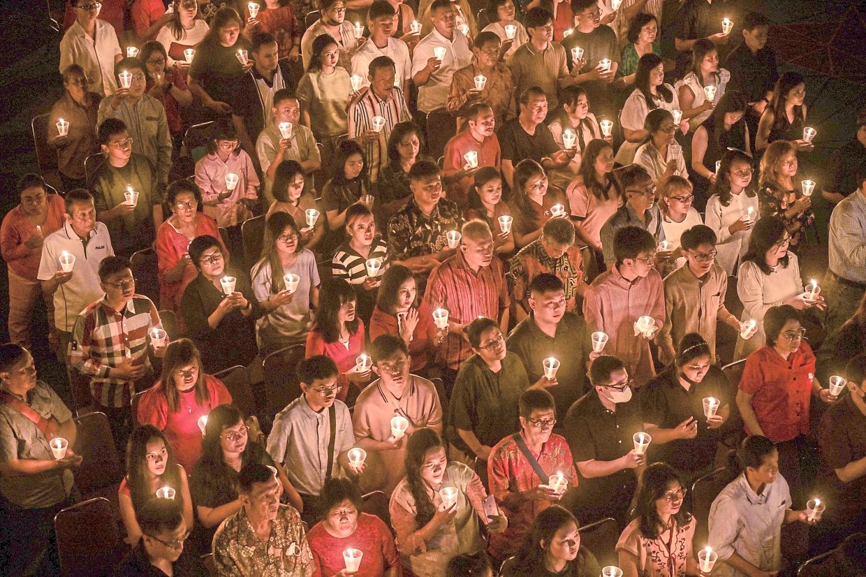 7. Christians lighting candles during a Christmas Day Mass at Bethany Church in Surabaya. — AFP