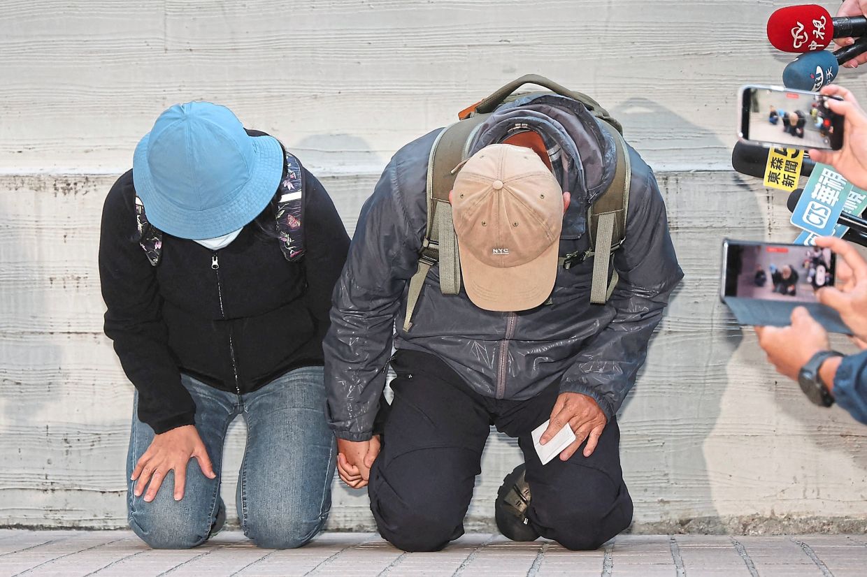 6. The parents of the suspect in the Dec 19 Taipei metro stabbings kneeling in apology during an appearance at the Taipei City Forensic Inspection and Autopsy Center. — CNA/ AFP