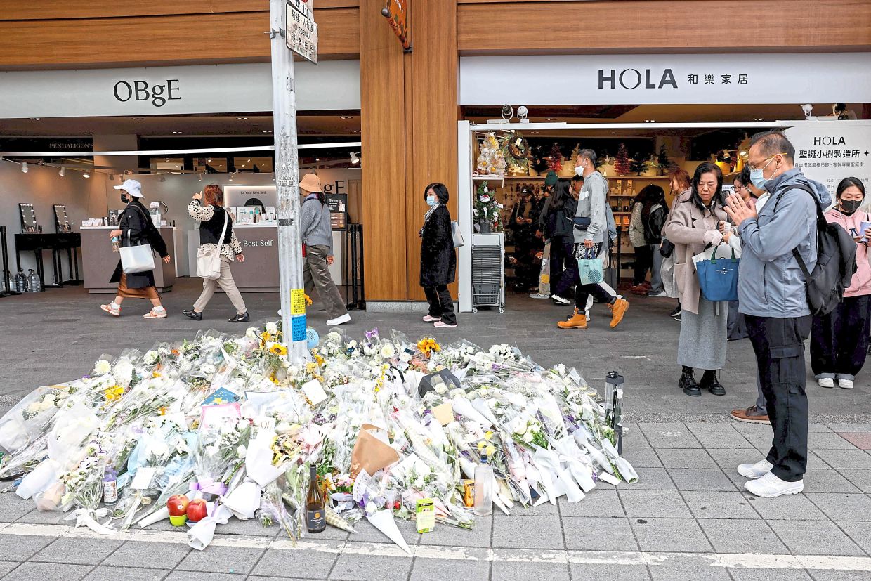 8. People paying their respects to the stabbing victims outside the Eslite Spectrum Nanxi store, near Zhongshan station, in Taipei. — Reuters