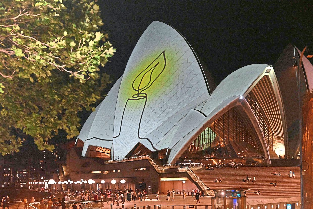 9. The Sydney Opera House is illuminated with candlelights on Dec 21, as part of a national day of reflection honouring the victims of the Bondi Beach terrorist attack. — AFP