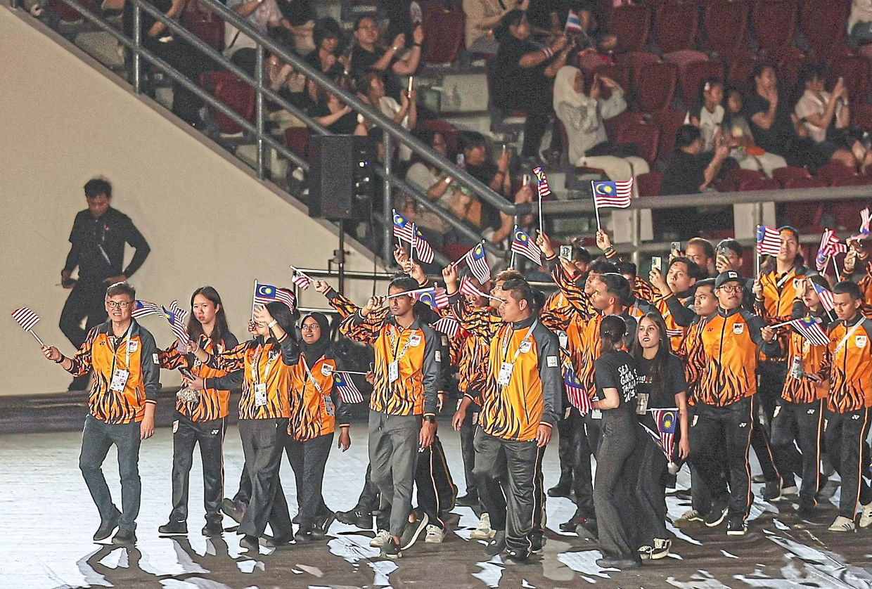 1. The Malaysian contingent entering the Rajamangala National Stadium for the 33rd Sea Games closing ceremony. — Bernama