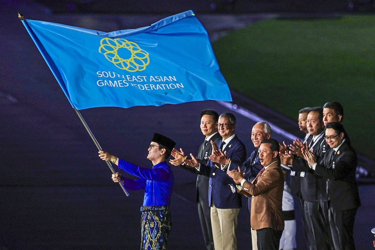 2. Youth and Sports Minister Dr Mohammed Taufiq Johari waving the South East Asian Games Federation flag at the closing ceremony. — Bernama
