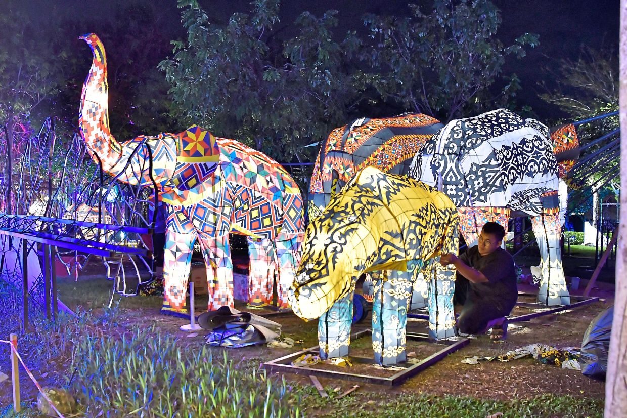 3. A worker putting the finishing touches on an elepant lantern. — Bernama