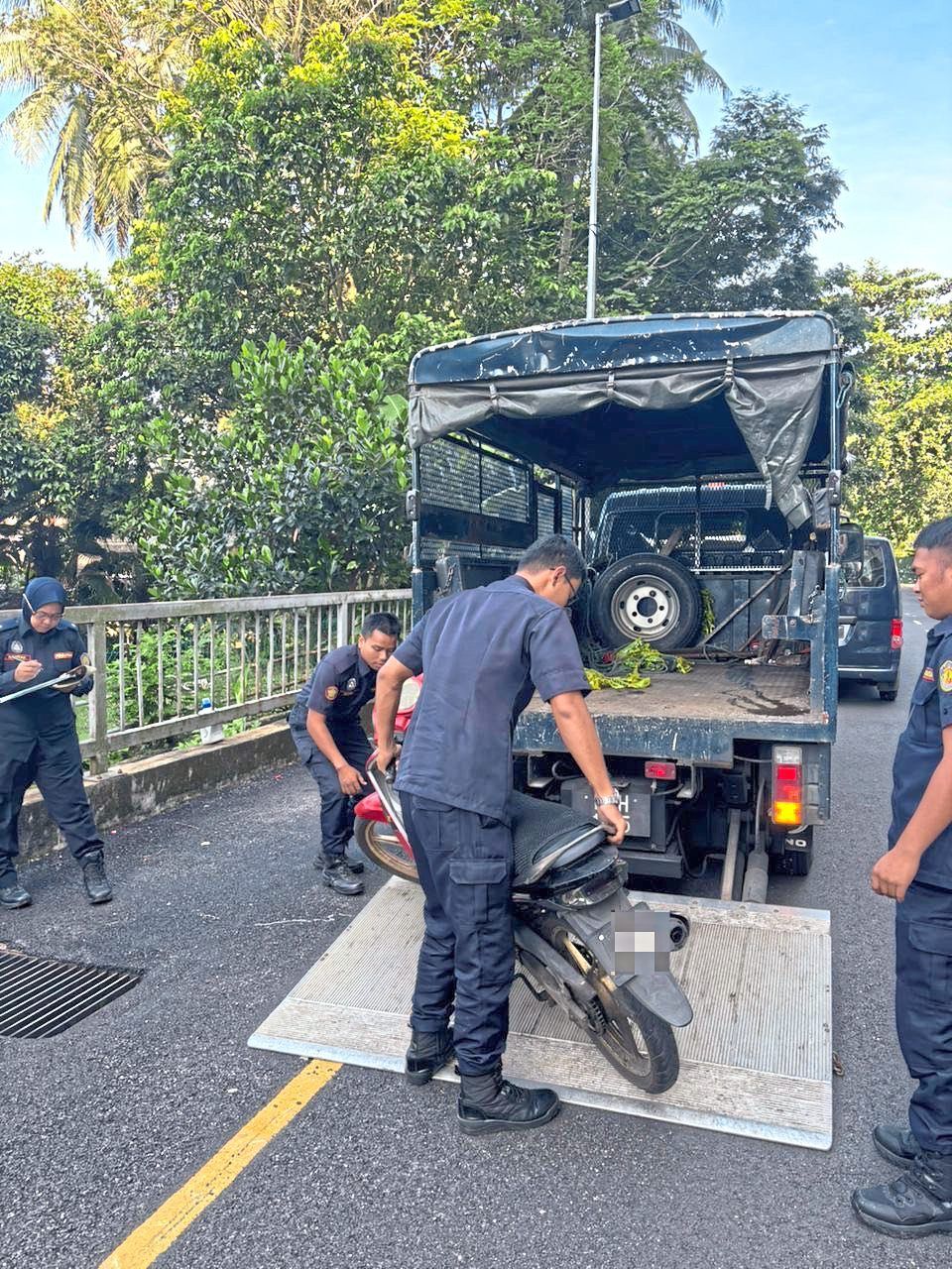 MPAJ officers removing an abandoned motorcycle as part of its enforcement action in Ampang Jaya. — Courtesy photos 
