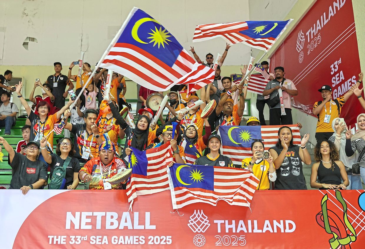 Supporters cheering during the netball final against Singapore.— Photos: IZZRAFIQ ALIAS and GLENN GUAN/The Star