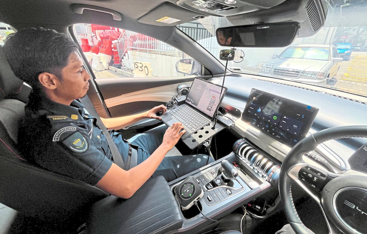 Penang Island City Council (MBPP) enforcement personnel operating the Automated Number Plate Recognition (ANPR) system in George Town.