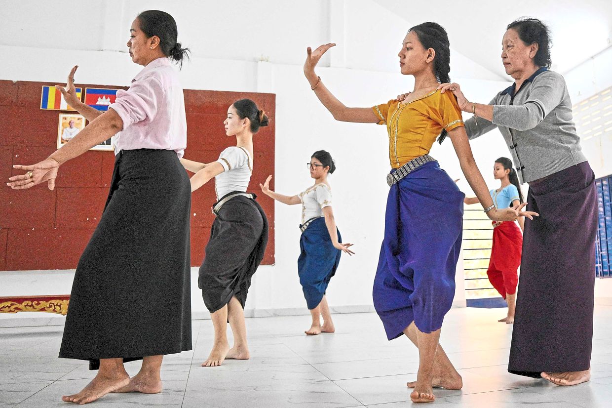 Senior dance teacher Pen Sokhuon (right) remains active in the studio, guiding young students. Photo: AFP