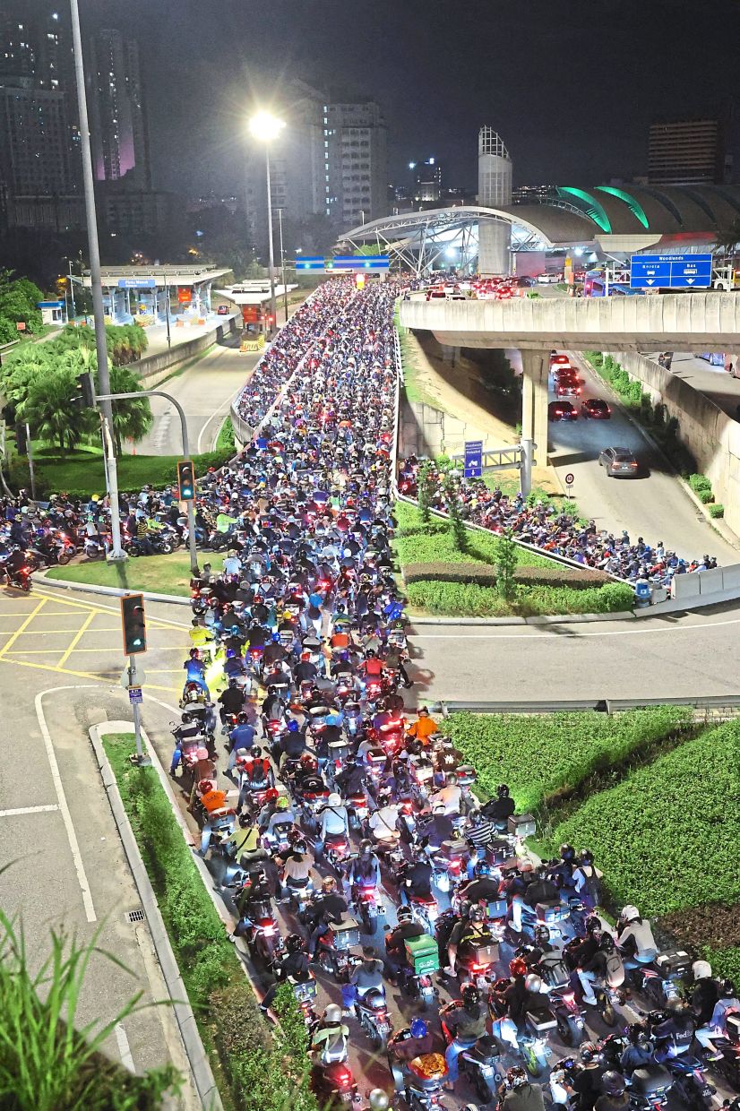 Motorcyclists queuing outside the Bangunan Sultan Iskandar Customs, Immigration and Quarantine complex (BSI) after tighter security measures were implemented last year. — Filepic