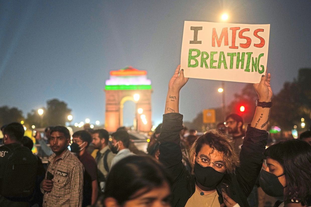 Taking a stand: A file photo of a person holding a sign during a protest against what they called the government’s lack of action to combat air pollution in New Delhi. — AP