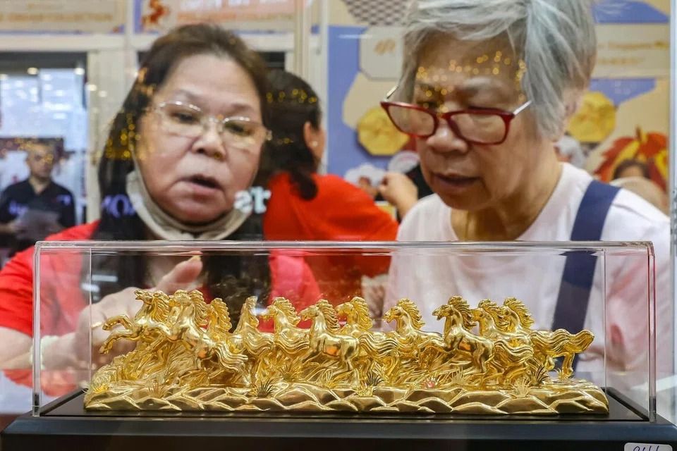 Shoppers at the Singapore Mint Lunar Fair admiring the majestic 12-horse figurine set, Jan 1. - Photo: ST