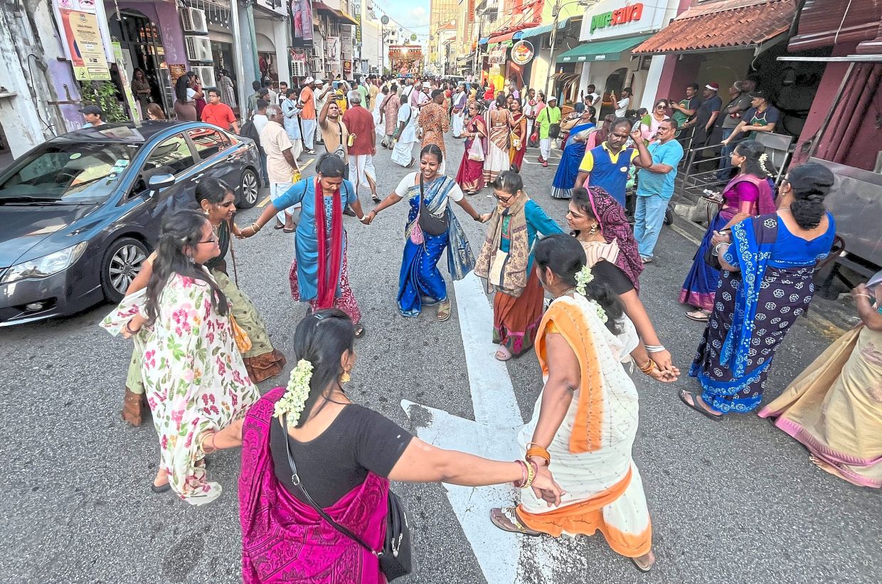 Devotees dancing and chanting devotional prayers as the chariot moves along Lebuh Penang.