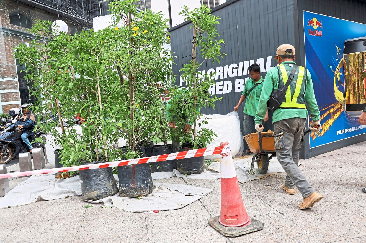 Workers carry out last-minute landscaping works along Jalan Bukit Bintang ahead of the launch of the I Lite U @ Bukit Bintang initiative.