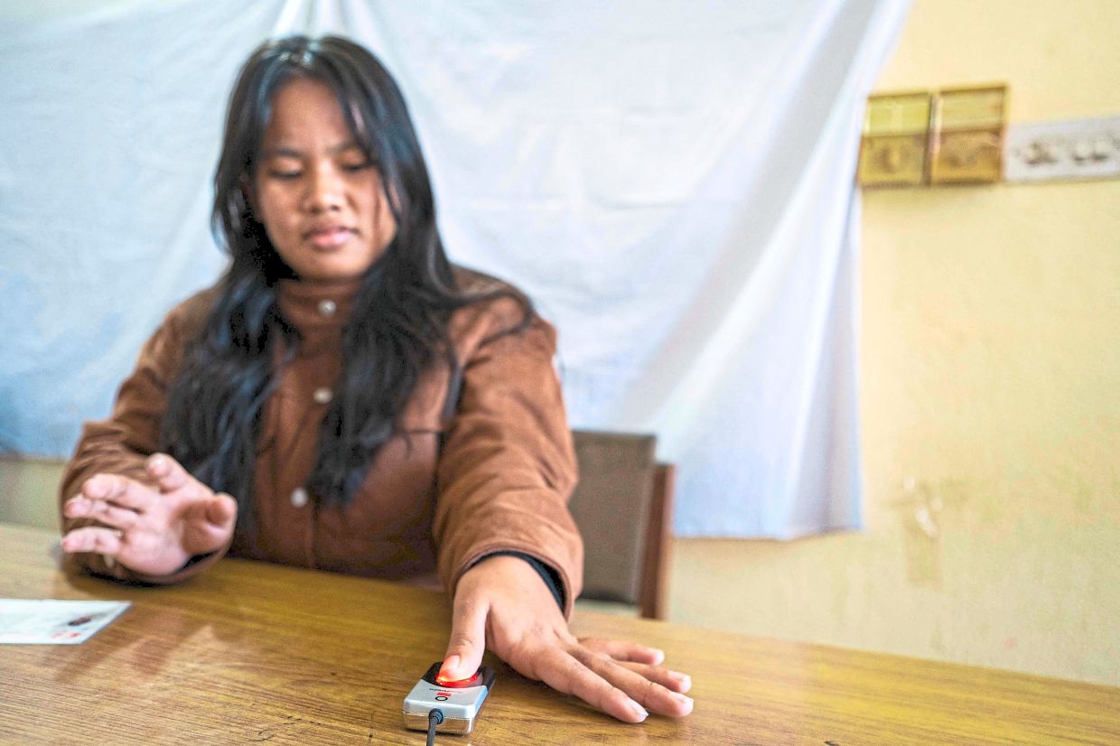 Voter boost: A young girl’s biometrics being taken by a poll official as she registers her name in the voter list at the District Election Office in Lalitpur, ahead of Nepal’s parliamentary elections. — AFP
