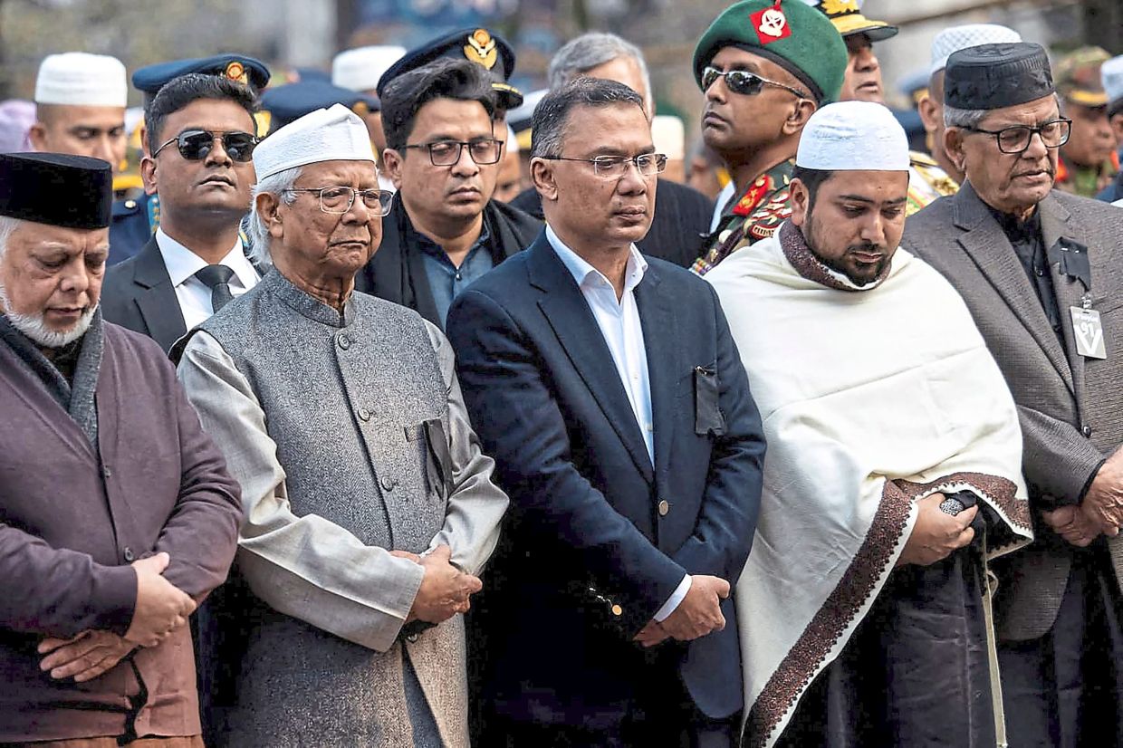 Final respects: Rahman (centre) standing alongside Yunus (second from left) during the burial ceremony of his mother, Zia, a day after her death in Dhaka. — AFP