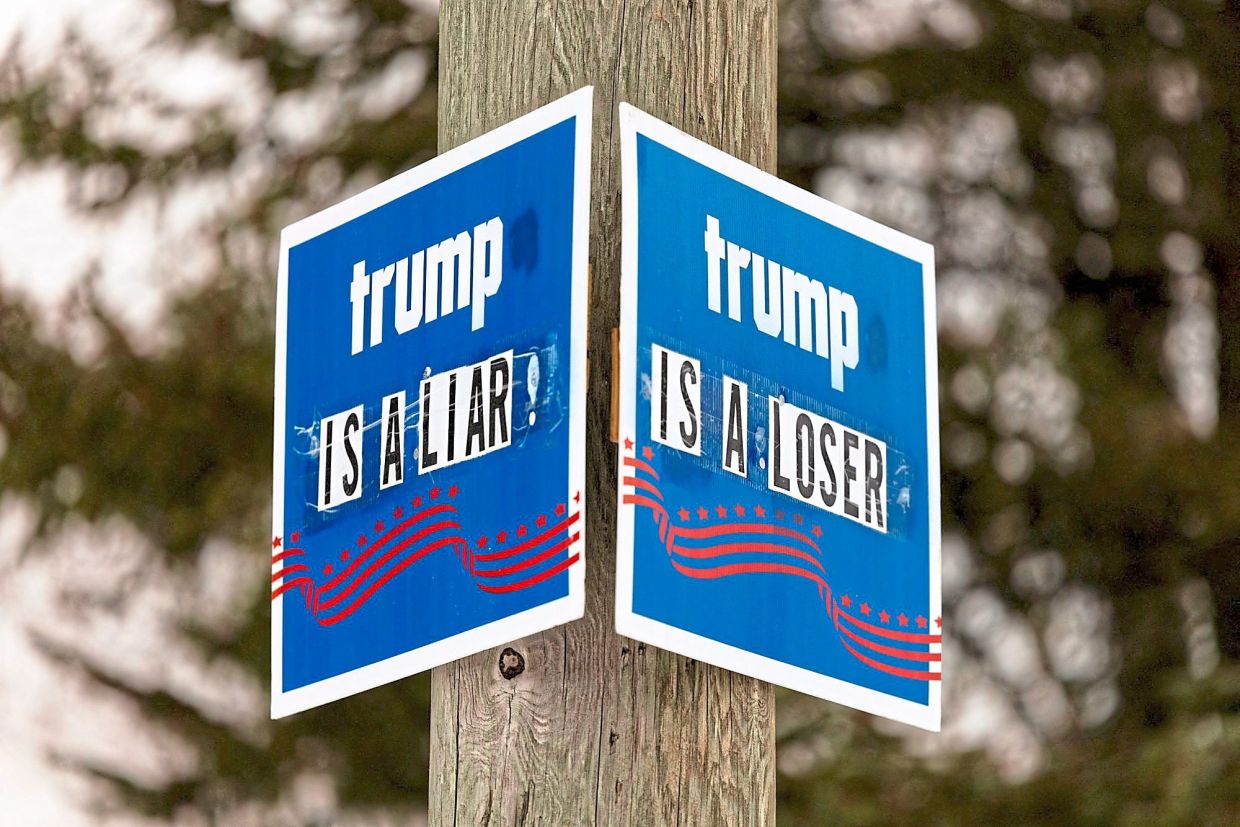 Signs critical of Trump are posted on a utility pole in Port Huron, Michigan. Americans who are struggling with the basic cost of living want the president to speed up on his campaign promises.— Reuters