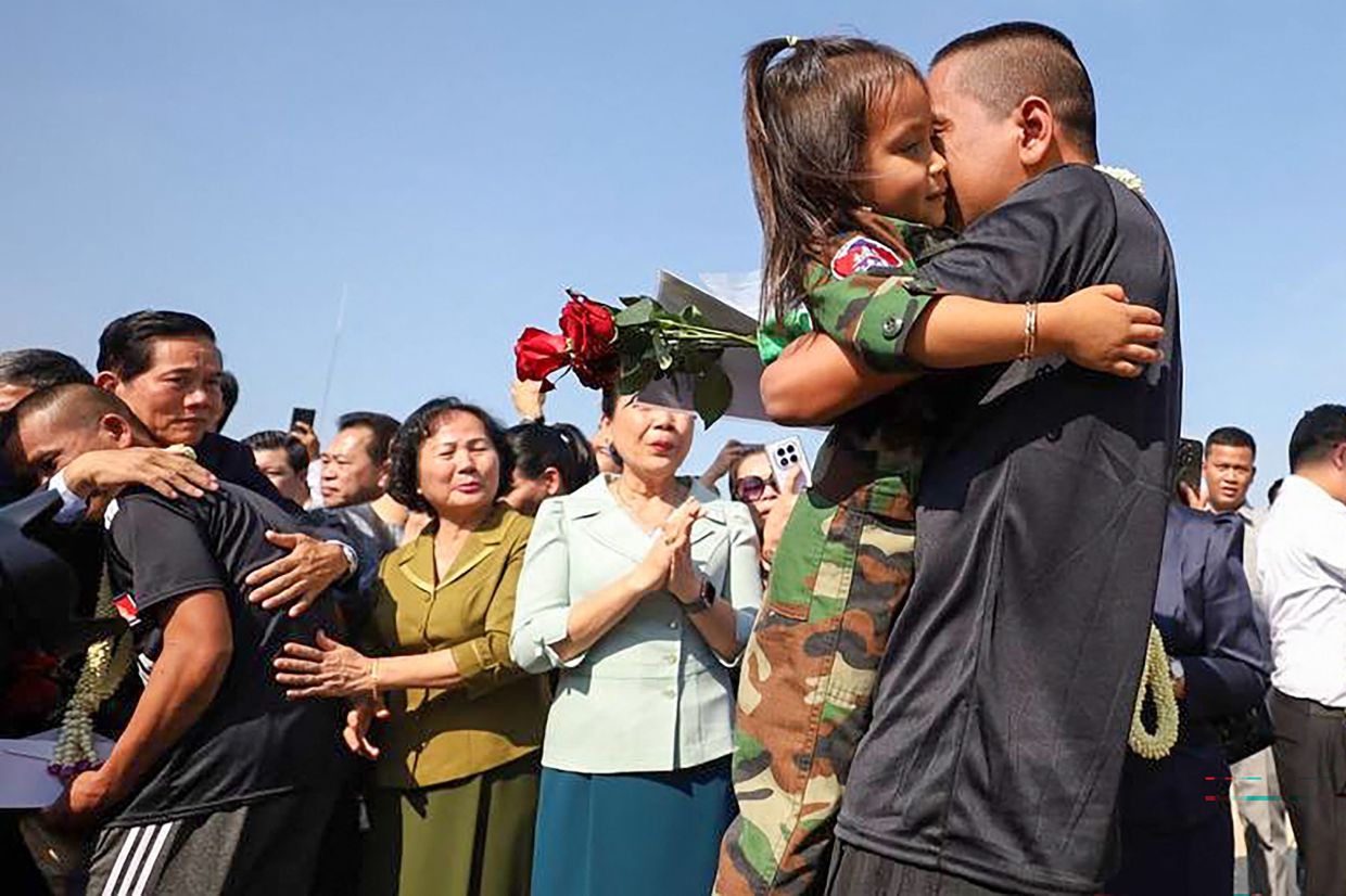 A Cambodian soldier (right), who had been captured by Thai soldiers in July, hugging his daughter as he arrives with other released soldiers at the former international airport in Phnom Penh on December 31, 2025. Thailand has released 18 Cambodian soldiers captured in July, both governments said, after a fresh ceasefire between the neighbours held for more than three days following weeks of deadly border clashes. -- Photo by AKP via AFP