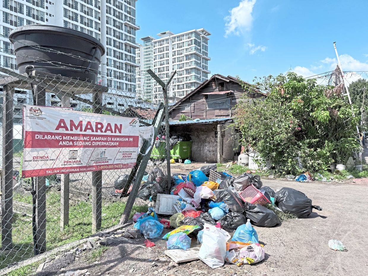 Despite a banner warning not to throw rubbish, people in this Kuala Lumpur neighbourhood continue to throw rubbish in open spaces.