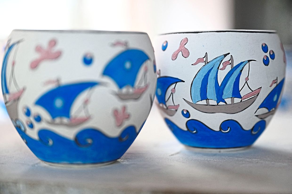 Traditional Turkish patterns painted on plates, coffee cups, vases and bowls made with tile in Iznik. Known for their intricate designs and lustrous colours, Iznik tiles are widely seen as the pinnacle of Ottoman artwork.-AFP