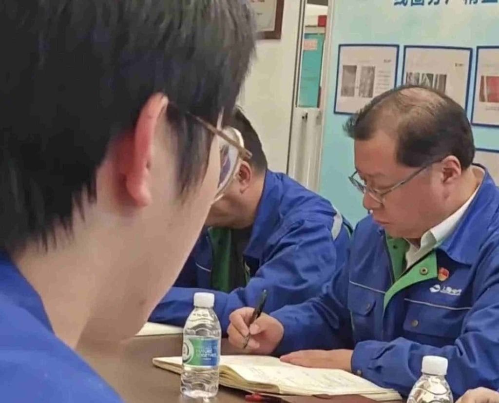 A diligent Fu, right, hard at work in his job as a trade union worker. - Photo: QQ.com