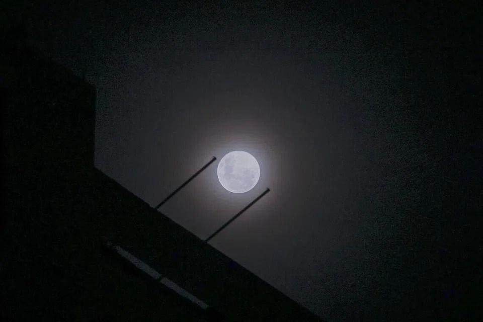 Wolf supermoon peers through cloudy night sky above Singapore