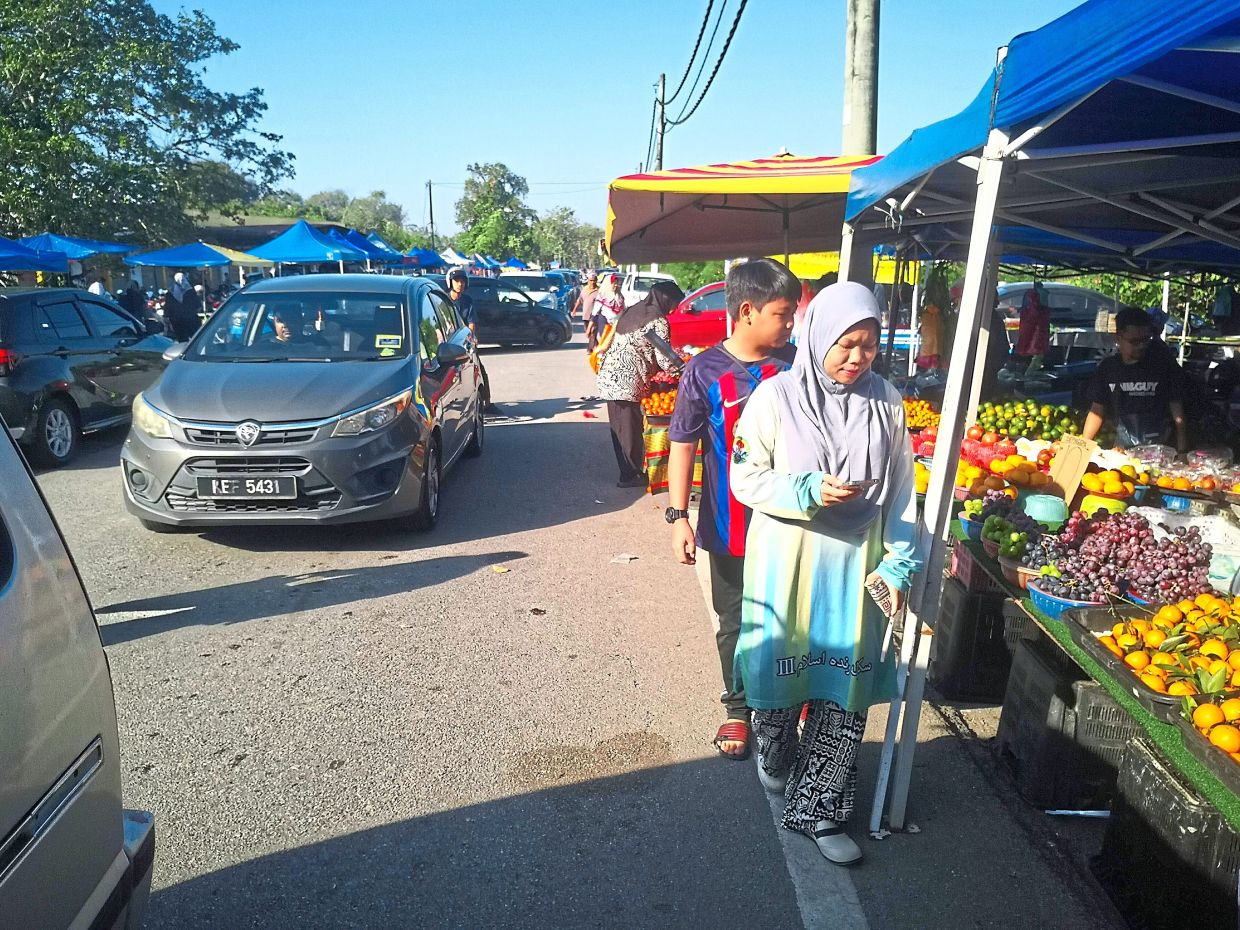 Stalls line both sides of the road at this busy market.
