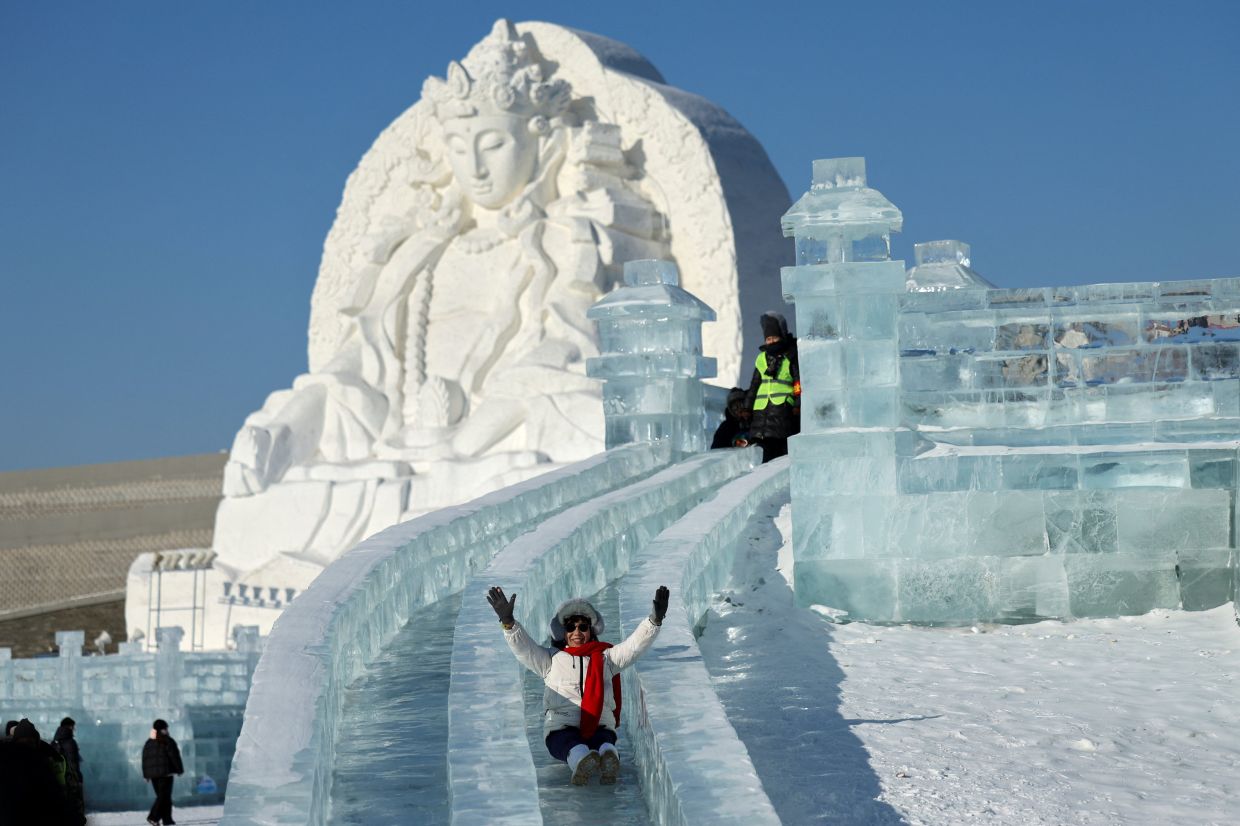 A person slides down an ice slide at the annual Ice and Snow Festival in Harbin, Heilongjiang Province, China, on Sunday, January 4, 2026.--Photo: REUTERS/Go Nakamura