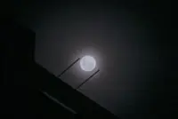 Wolf supermoon peers through cloudy night sky above Singapore