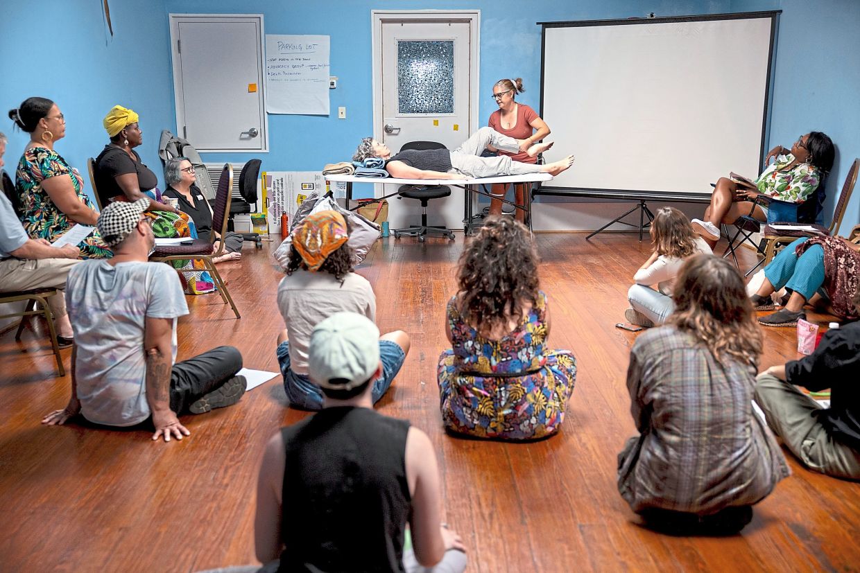 Nurse Ana Kanellos demonstrates home caregiving techniques. Photo: Verite News and CatchLight Local/Report for America/TNS/Christina Botic