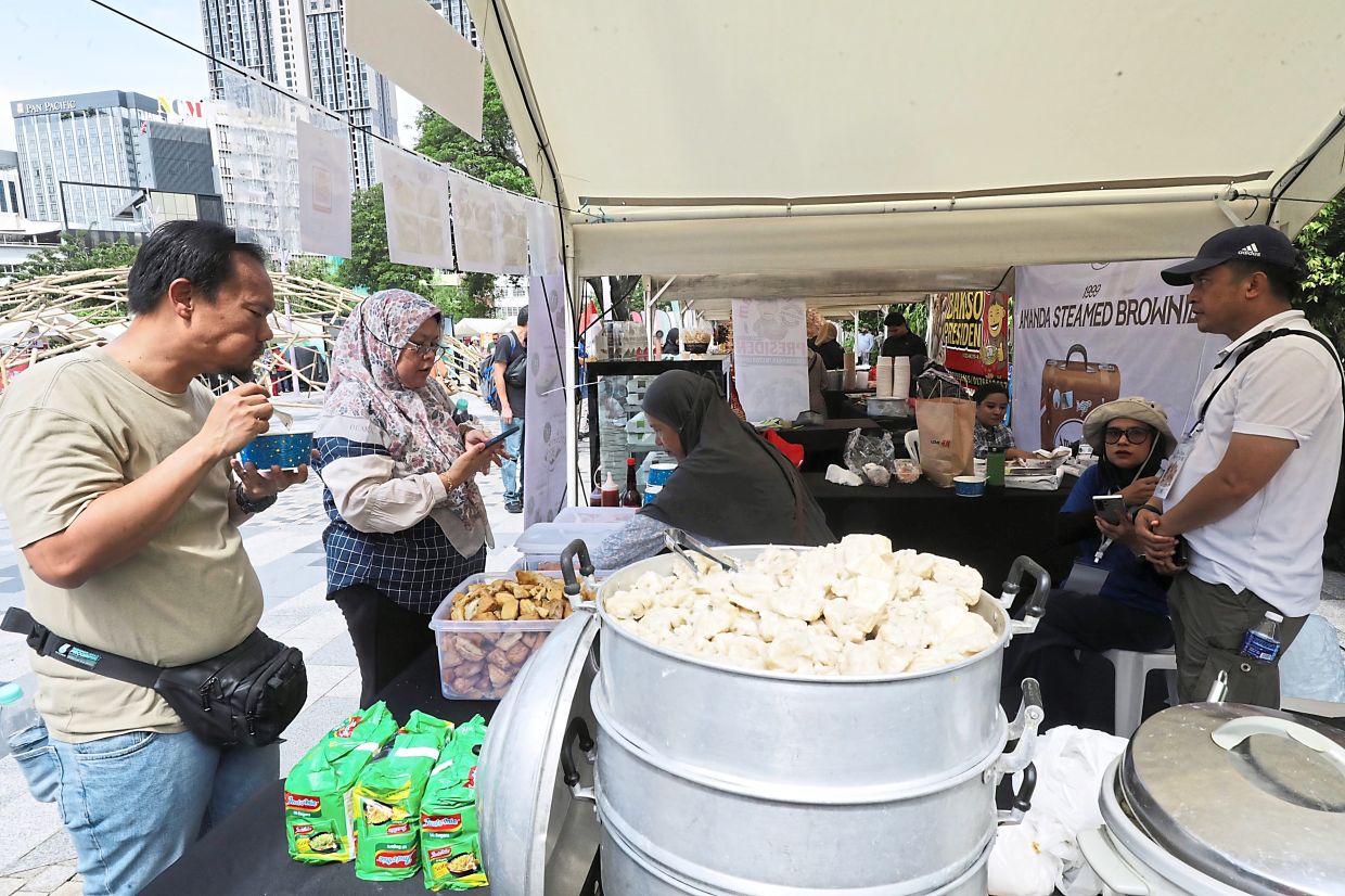 A booth offering food from Indonesia (above) drawing visitors in at the sun-soaked Gebyar Nusantara held at The Exchange TRX (right). — Photos: SAMUEL ONG/The Star