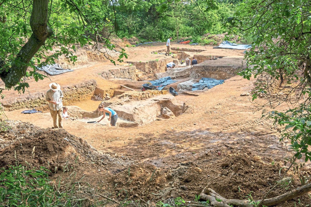 Researchers work at an excavation site in Barnham, uncovering 400,000-year-old pond sediments. – AP