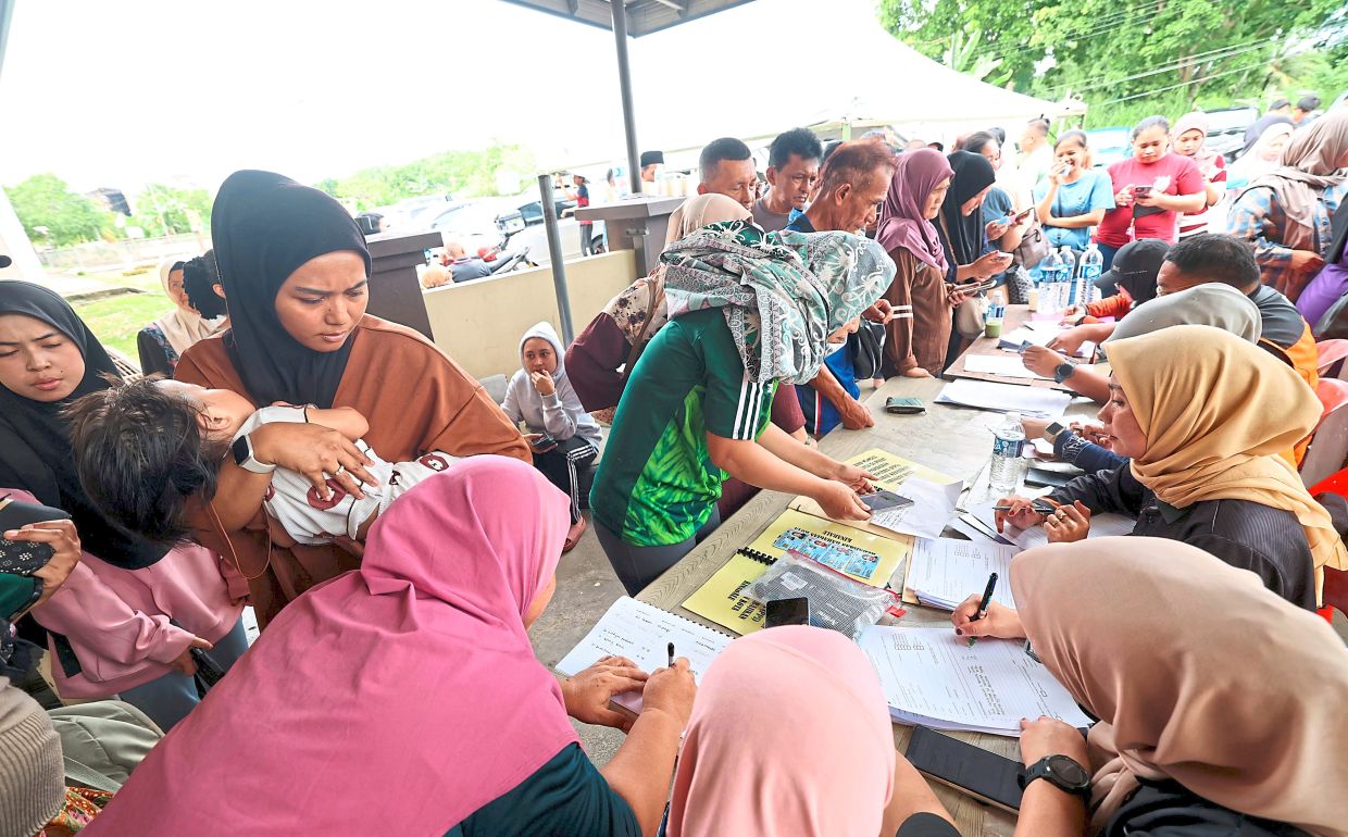 Seeking help: Flood victims registering with the Welfare Department at Al-Munir Mosque. — Bernama
