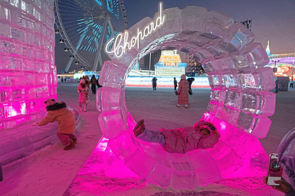 Cool spot to relax: A child sleeping in an ice sculpture during the annual festival in Harbin. — AP