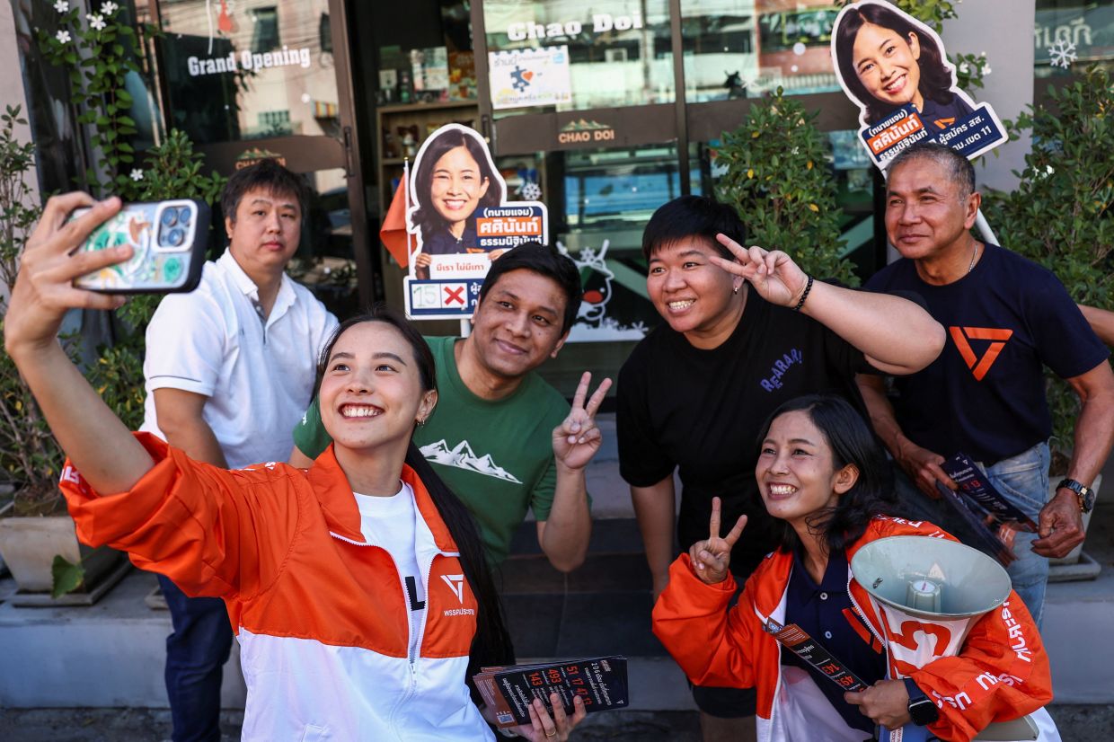 Rukchanok, nicknamed Ice, Srinork, 31, an activist-turned party-list election candidate for the People's Party, takes a selfie with supporters during a general election campaign event with People's Party candidates ahead of Thailand's February 8 general election, in Bangkok, Thailand, on Monday, January 5, 2026. -- Photo: REUTERS/Chalinee Thirasupa