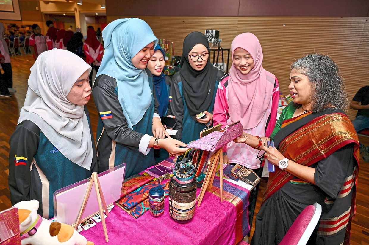 Sustainable fashion platform sareeUP founder Padmini Suppiah (right) upcycles pre-loved sarees into various everyday products such as purses and bags.