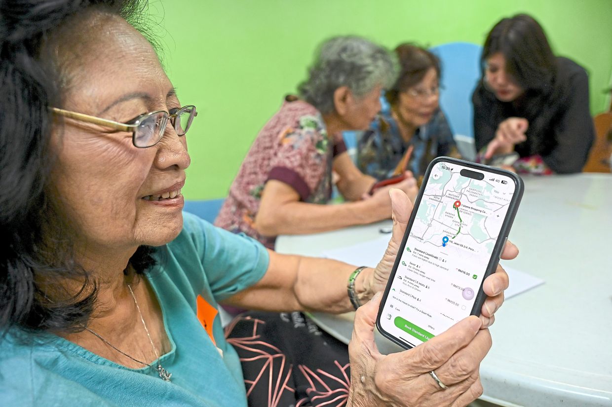A senior citizen learning about phone apps during a digital literacy class in Petaling Jaya.
