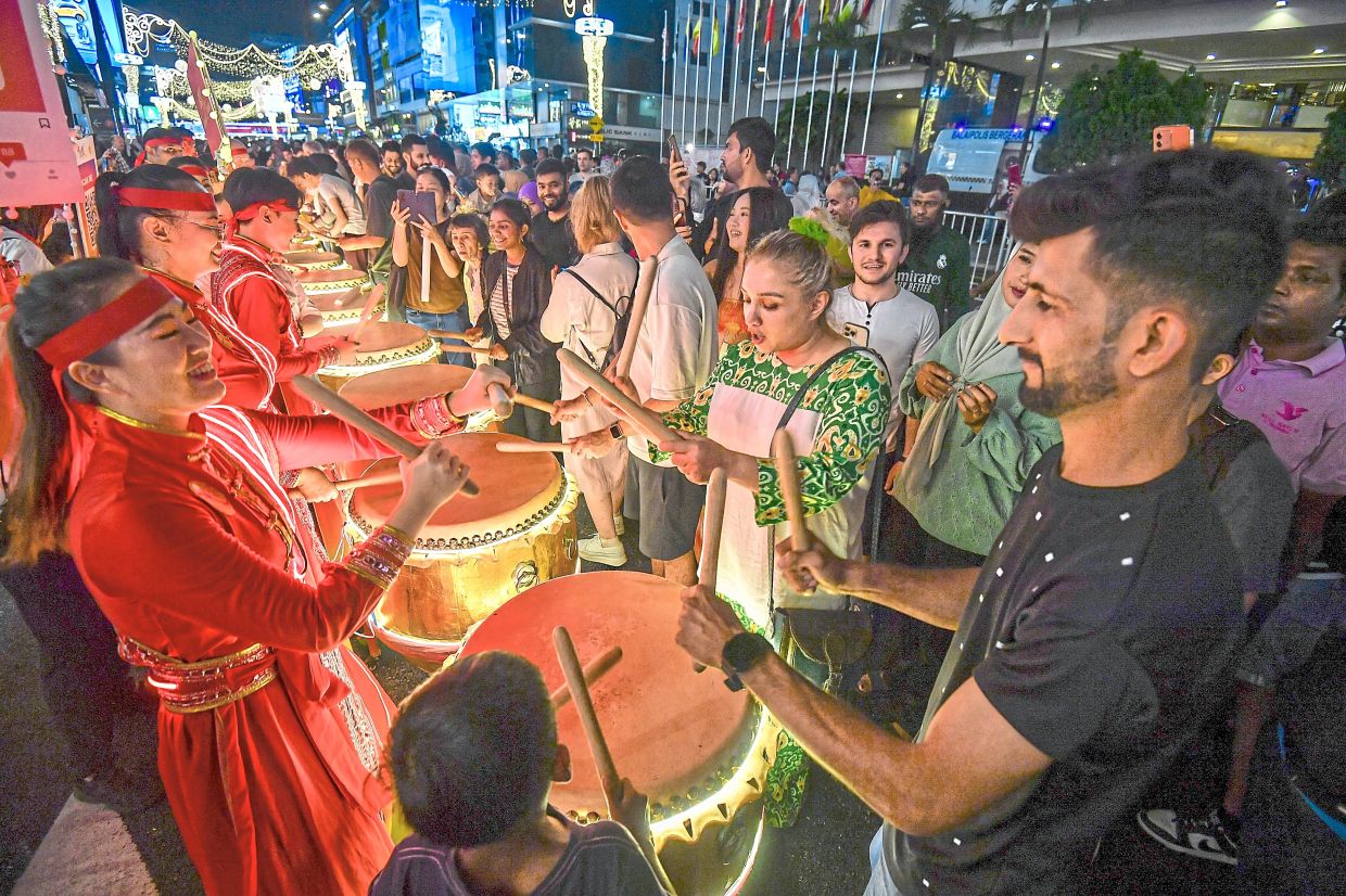 Bukit Bintang a vibrant showcase of Malaysiana, with tourists getting to try their hand at Chinese drums (right) .